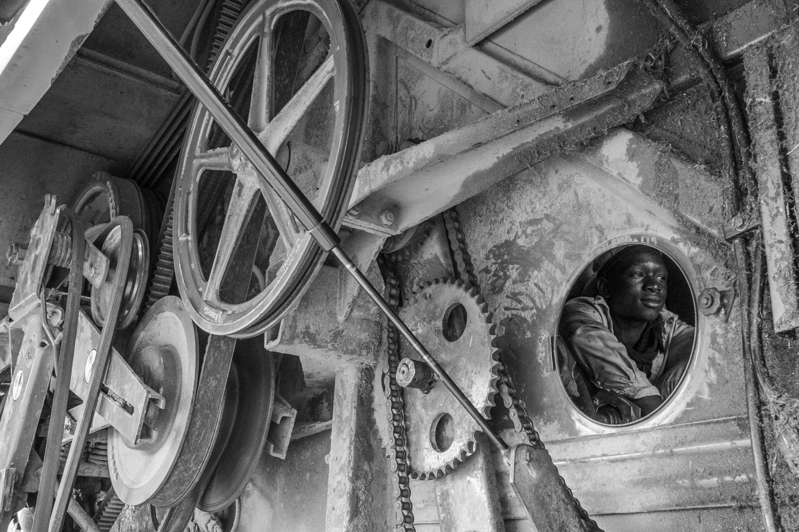 A black and white image of a man inside some machinery 