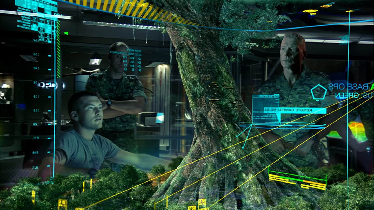 A holographic tree takes up most of the image. A few men sit behind it. 