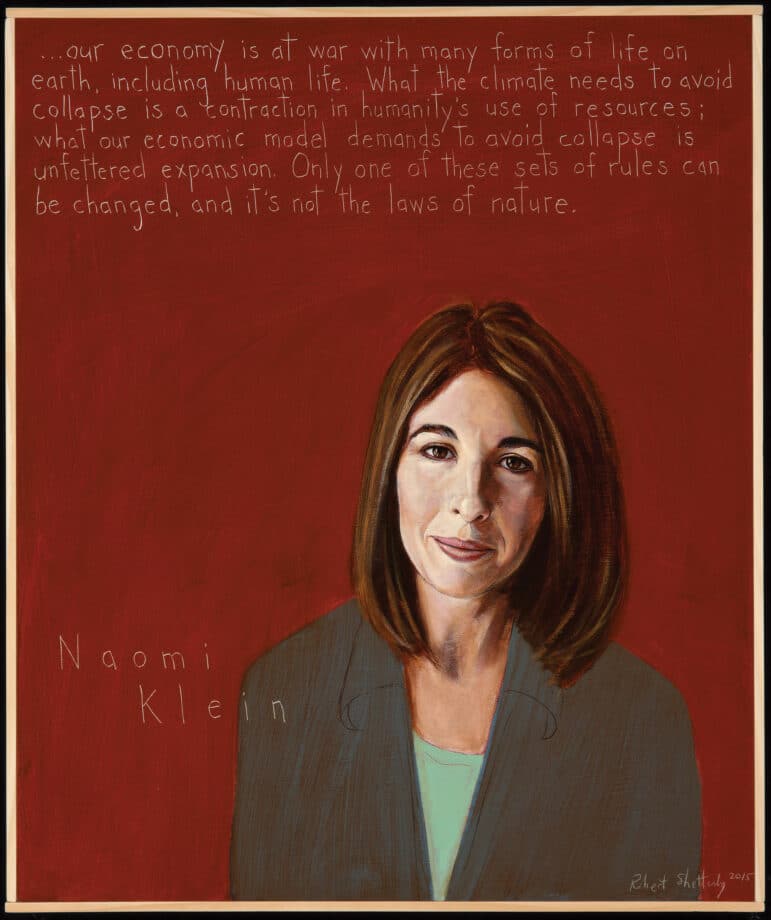 A portrait of Naomi Klein, a white woman with shoulder length brown hair. She wears a green shirt under a gray jacket, and her background is red. 